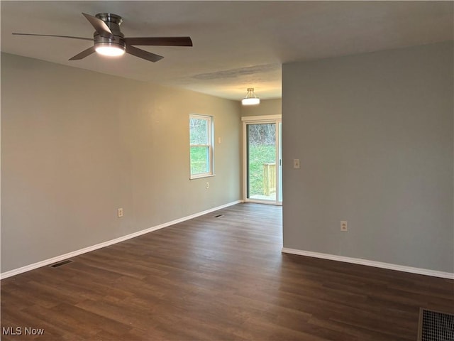 empty room with ceiling fan and dark hardwood / wood-style flooring