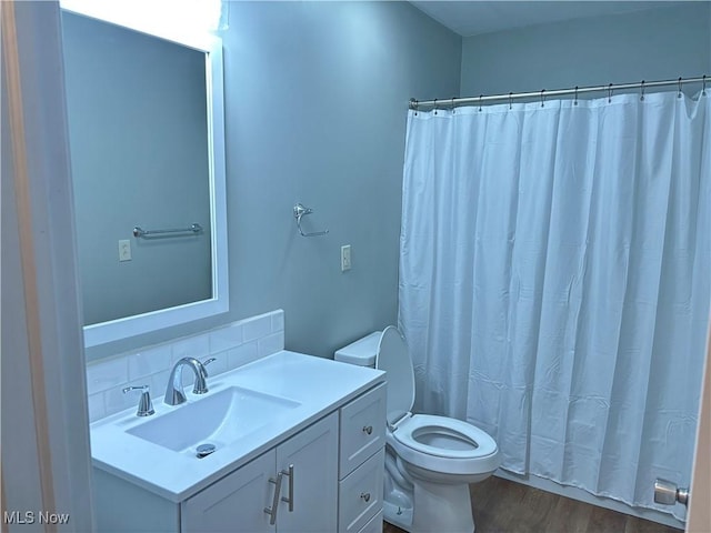 bathroom with vanity, backsplash, hardwood / wood-style flooring, a shower with shower curtain, and toilet