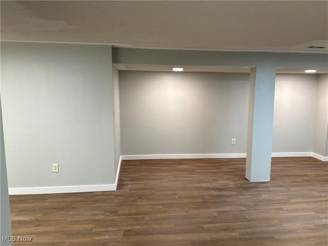 basement with dark hardwood / wood-style flooring