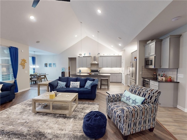 living room with light hardwood / wood-style flooring and vaulted ceiling