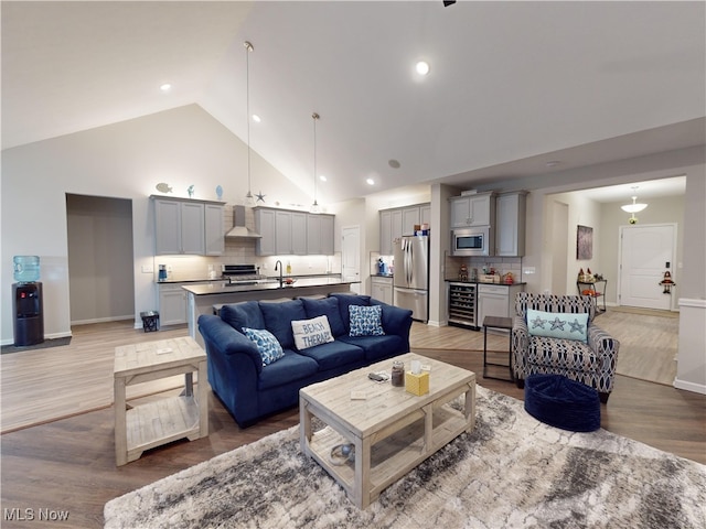 living room featuring wine cooler, high vaulted ceiling, and wood-type flooring