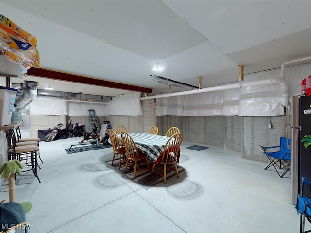 basement featuring stainless steel refrigerator