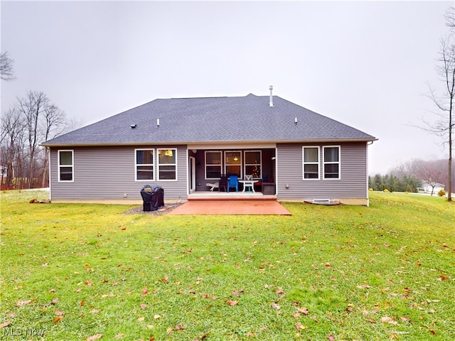 rear view of house with a lawn and a patio area