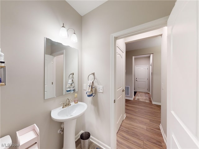 bathroom featuring hardwood / wood-style flooring, toilet, and sink