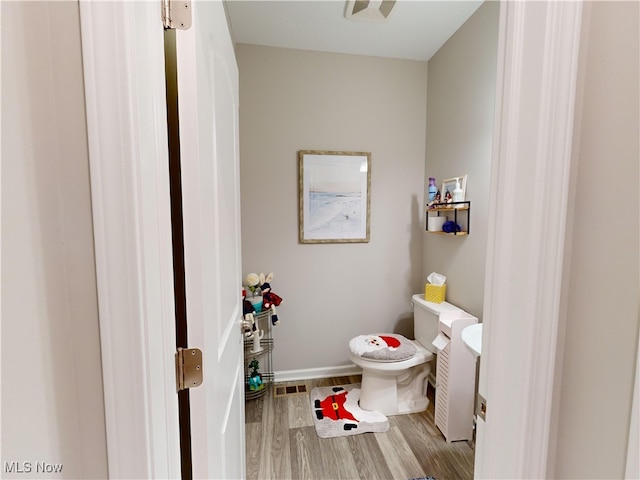 bathroom featuring hardwood / wood-style floors and toilet