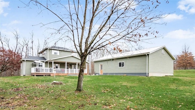 back of property with a lawn and a deck