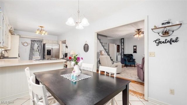 dining room featuring ceiling fan with notable chandelier, light tile patterned floors, and sink