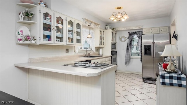 kitchen featuring pendant lighting, sink, a notable chandelier, kitchen peninsula, and stainless steel appliances