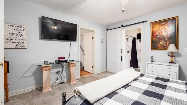 carpeted bedroom with a barn door and ensuite bath