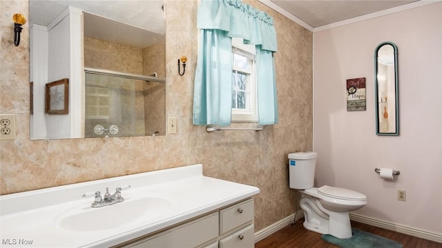 bathroom featuring crown molding, wood-type flooring, toilet, a shower with door, and vanity