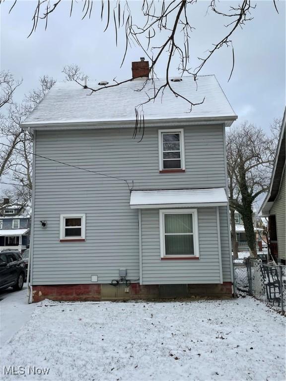 view of snow covered rear of property