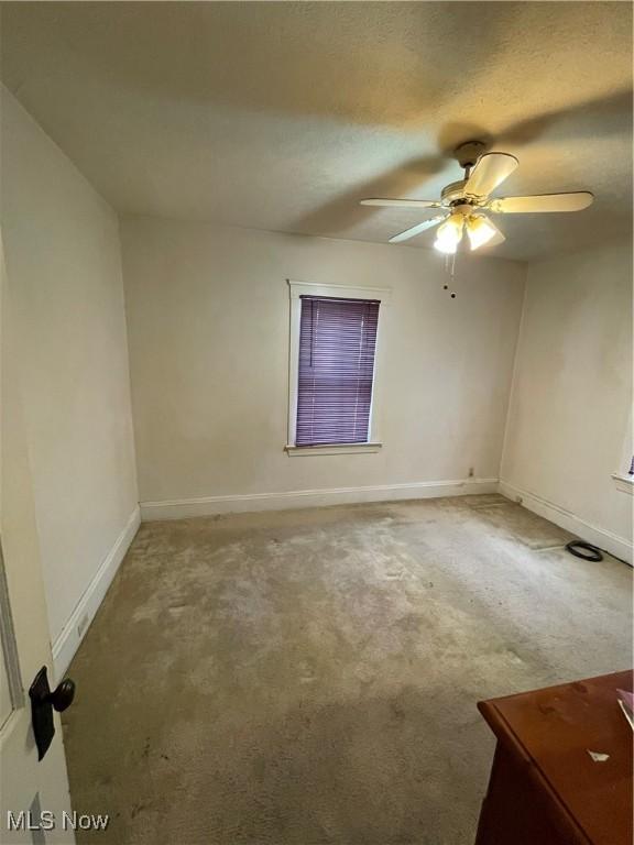 spare room featuring carpet and ceiling fan