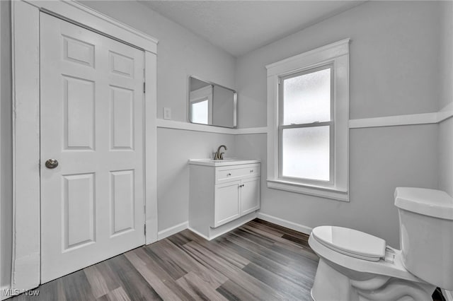 bathroom with hardwood / wood-style floors, vanity, a textured ceiling, and toilet