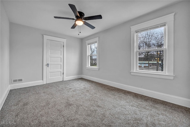 carpeted spare room with a wealth of natural light and ceiling fan