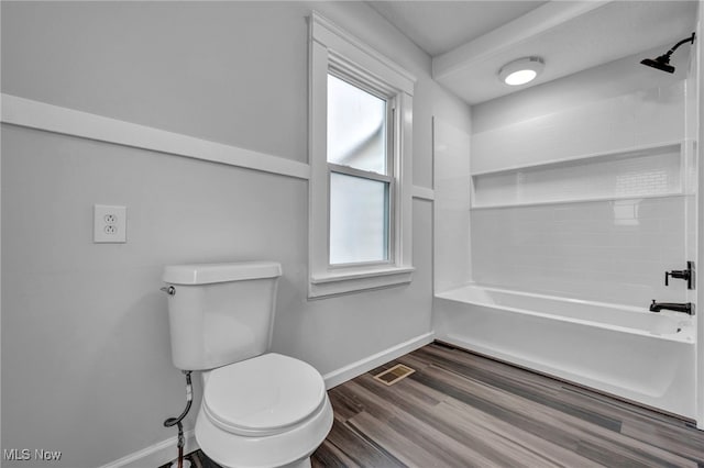 bathroom with a wealth of natural light, toilet, washtub / shower combination, and hardwood / wood-style flooring