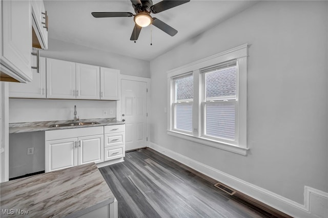 kitchen featuring dark hardwood / wood-style floors, ceiling fan, white cabinetry, and sink