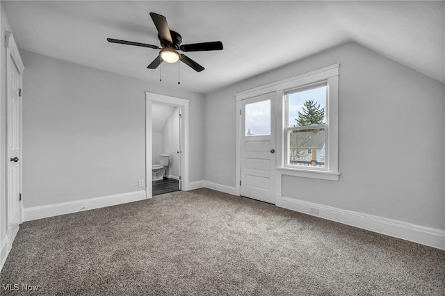 unfurnished bedroom with ceiling fan, carpet floors, ensuite bathroom, and vaulted ceiling