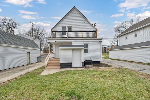 back of house with a lawn, a balcony, and central AC