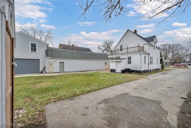 view of home's exterior featuring a lawn, central air condition unit, a balcony, and a garage