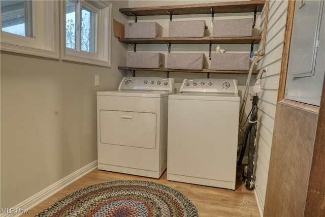 laundry area with washing machine and dryer and light hardwood / wood-style flooring