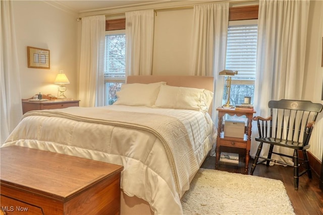 bedroom with wood-type flooring, multiple windows, and crown molding