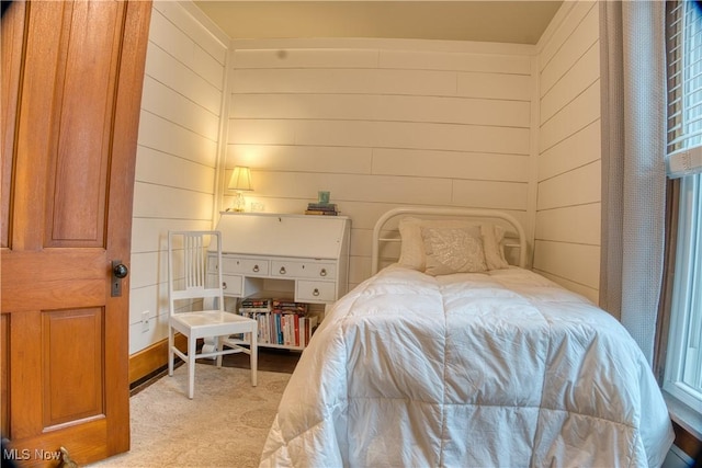 carpeted bedroom featuring wooden walls