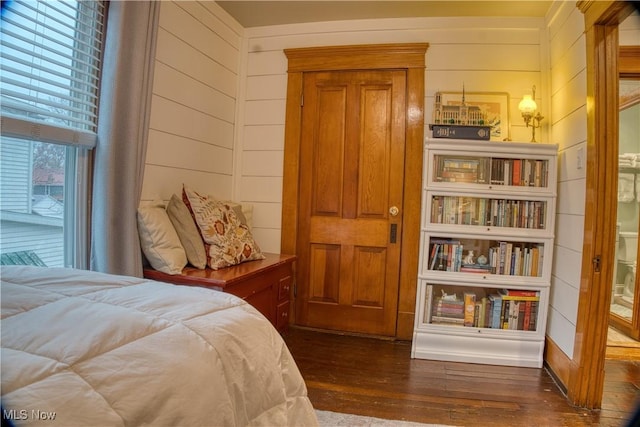 bedroom featuring dark hardwood / wood-style floors and wood walls