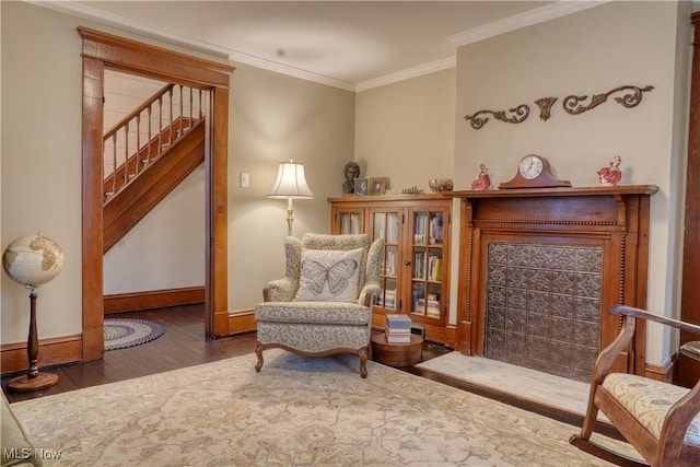 sitting room with dark hardwood / wood-style flooring and crown molding