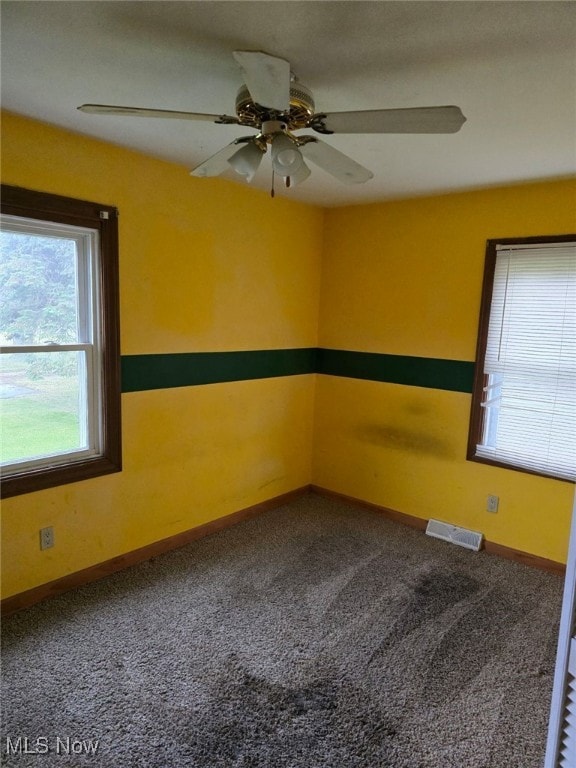 spare room with ceiling fan and carpet