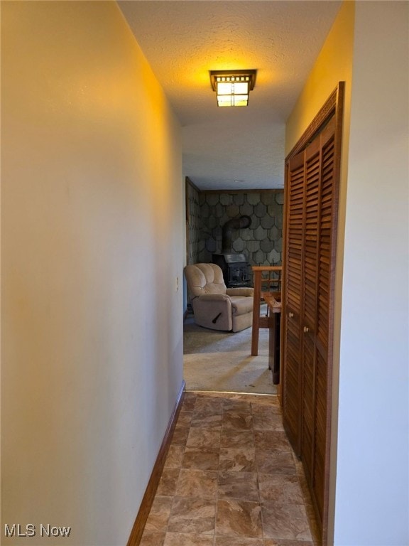 hall featuring a textured ceiling