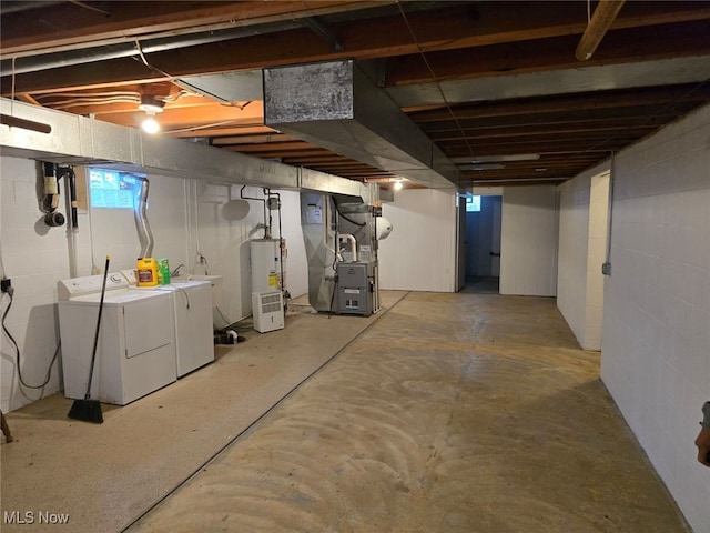 basement with water heater, independent washer and dryer, and heating unit