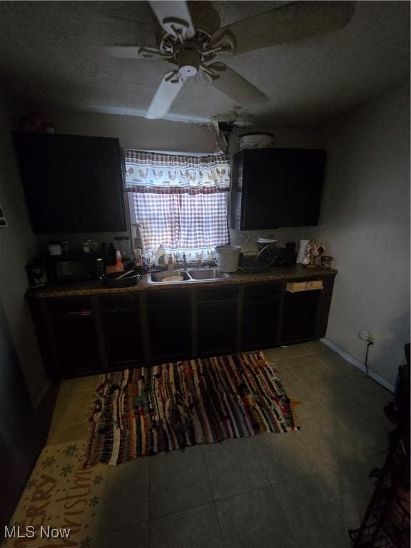 kitchen with tile patterned floors, ceiling fan, and sink