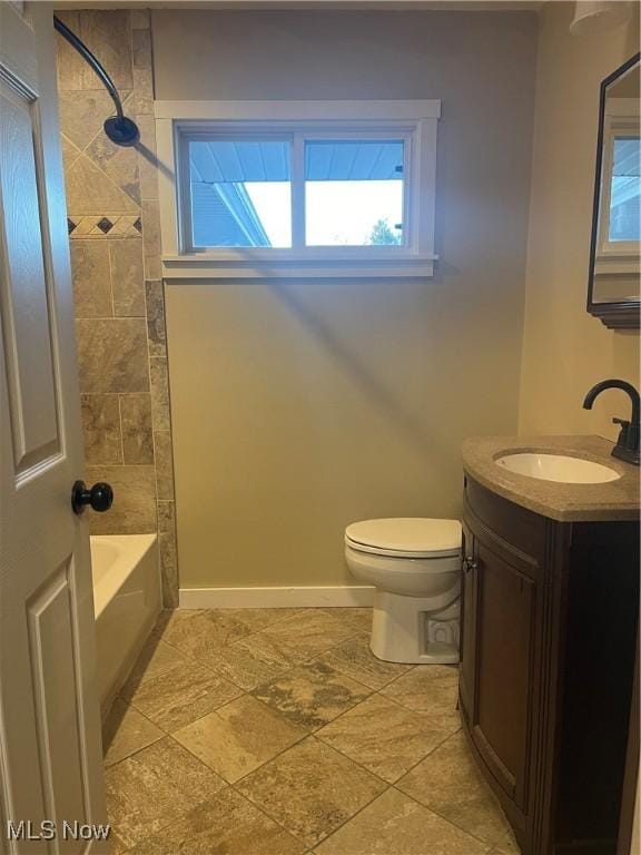 full bathroom featuring tiled shower / bath, vanity, and toilet