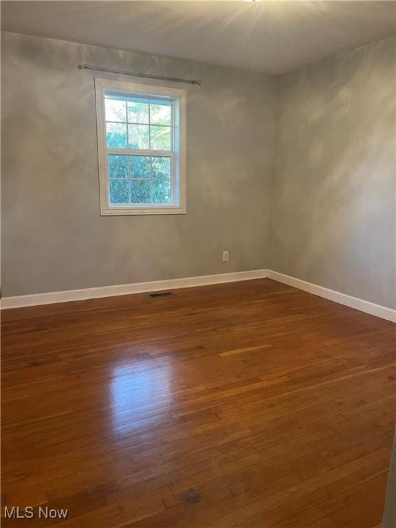 spare room with dark hardwood / wood-style flooring