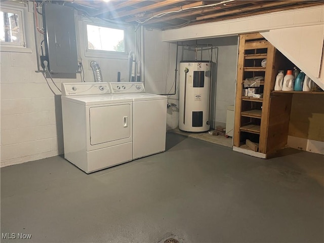 basement featuring electric panel, electric water heater, and washing machine and dryer