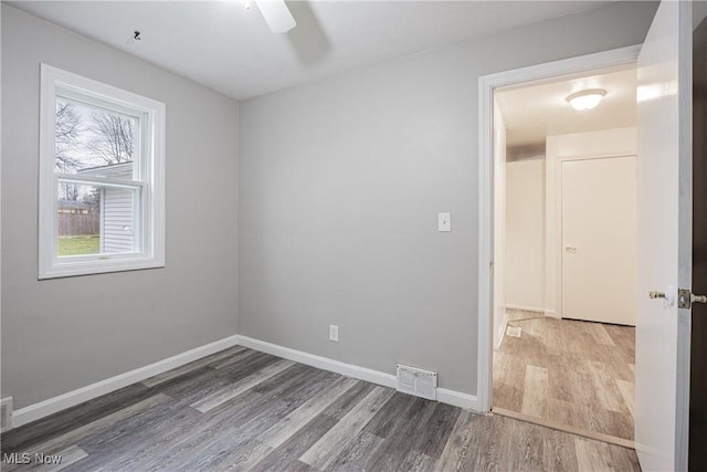 spare room with hardwood / wood-style floors and ceiling fan