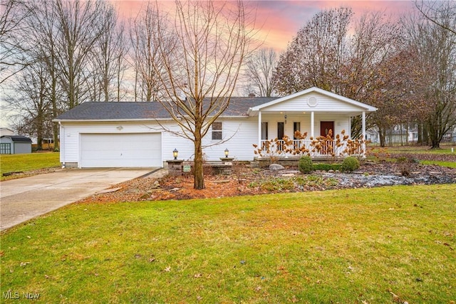 view of front facade with a porch, a garage, and a lawn