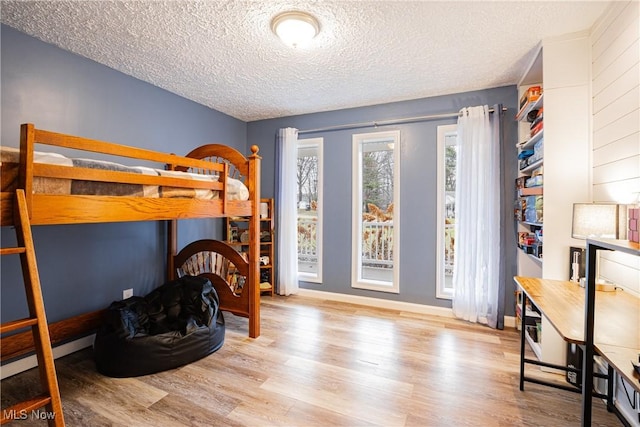 bedroom with a textured ceiling and light hardwood / wood-style flooring