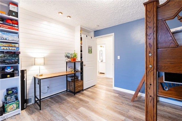 interior space with light wood-type flooring and a textured ceiling