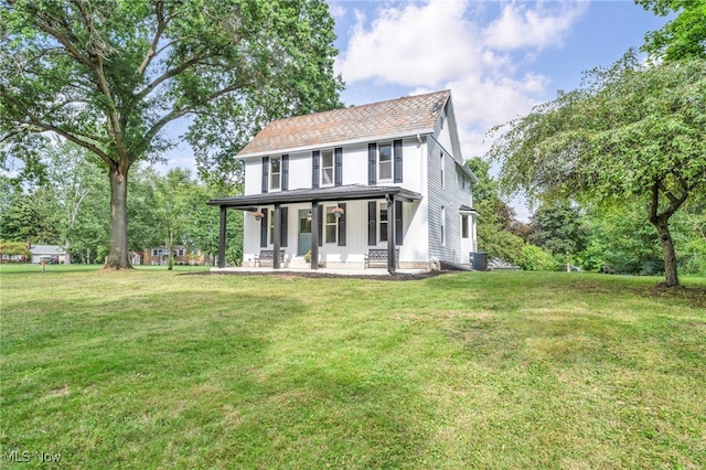 colonial home featuring central AC unit, a porch, and a front lawn