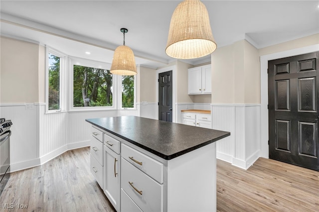 kitchen with pendant lighting, a center island, a healthy amount of sunlight, white cabinets, and light hardwood / wood-style floors