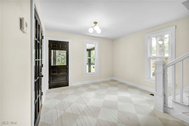 foyer entrance with plenty of natural light and an inviting chandelier