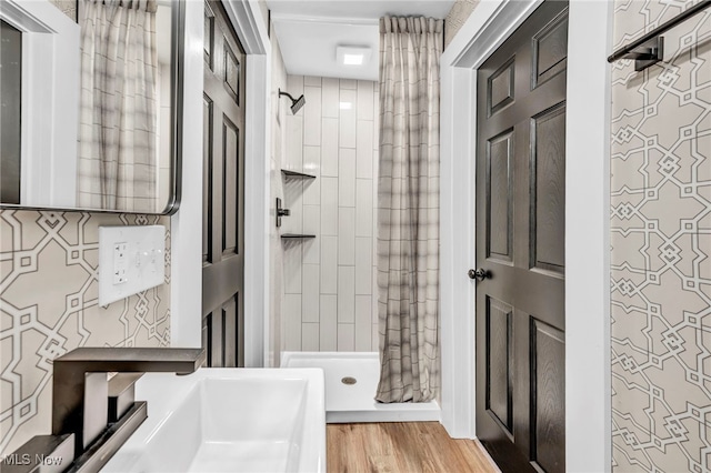 bathroom featuring a tile shower and hardwood / wood-style flooring