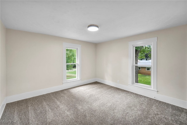 carpeted spare room featuring plenty of natural light