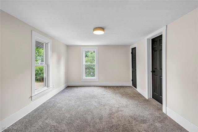 carpeted spare room featuring plenty of natural light