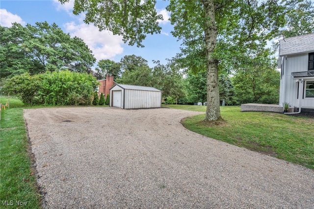 view of yard featuring a garage and an outbuilding