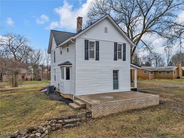 rear view of house featuring a patio, a yard, and cooling unit