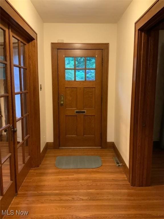 doorway with french doors and light hardwood / wood-style flooring