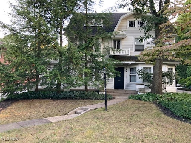 view of front of home featuring a balcony and a front yard