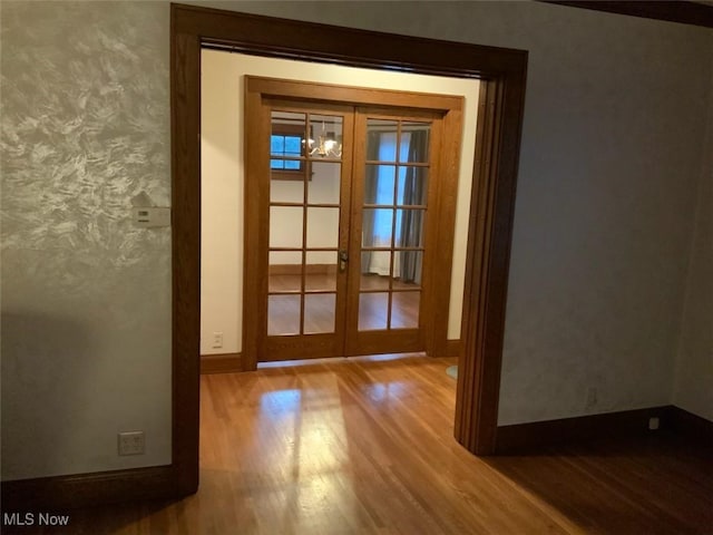 doorway featuring french doors, a notable chandelier, and hardwood / wood-style floors